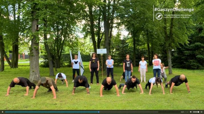 Zdjęcie przedstawiające kadr z filmu - robiący pompki pracownicy ORWLP w Bedoniu podczas akcji charytatywnej